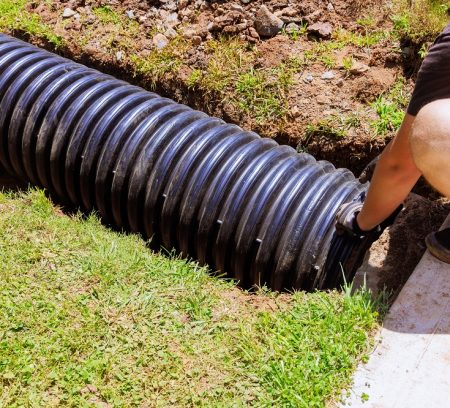 Installation of plastic black pipes for draining rainwater to central collector