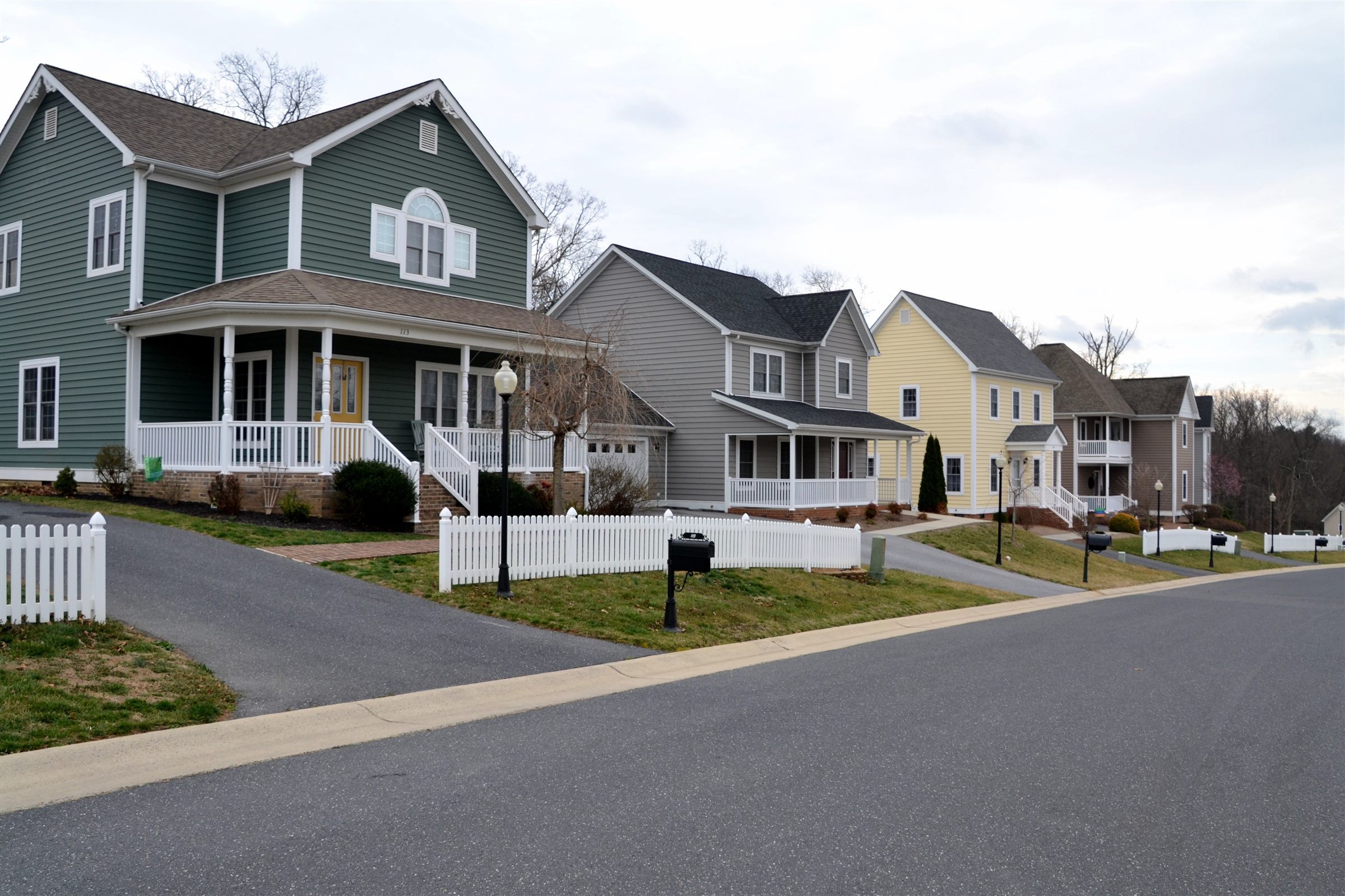 Suburban street of two-story houses with white picket fences